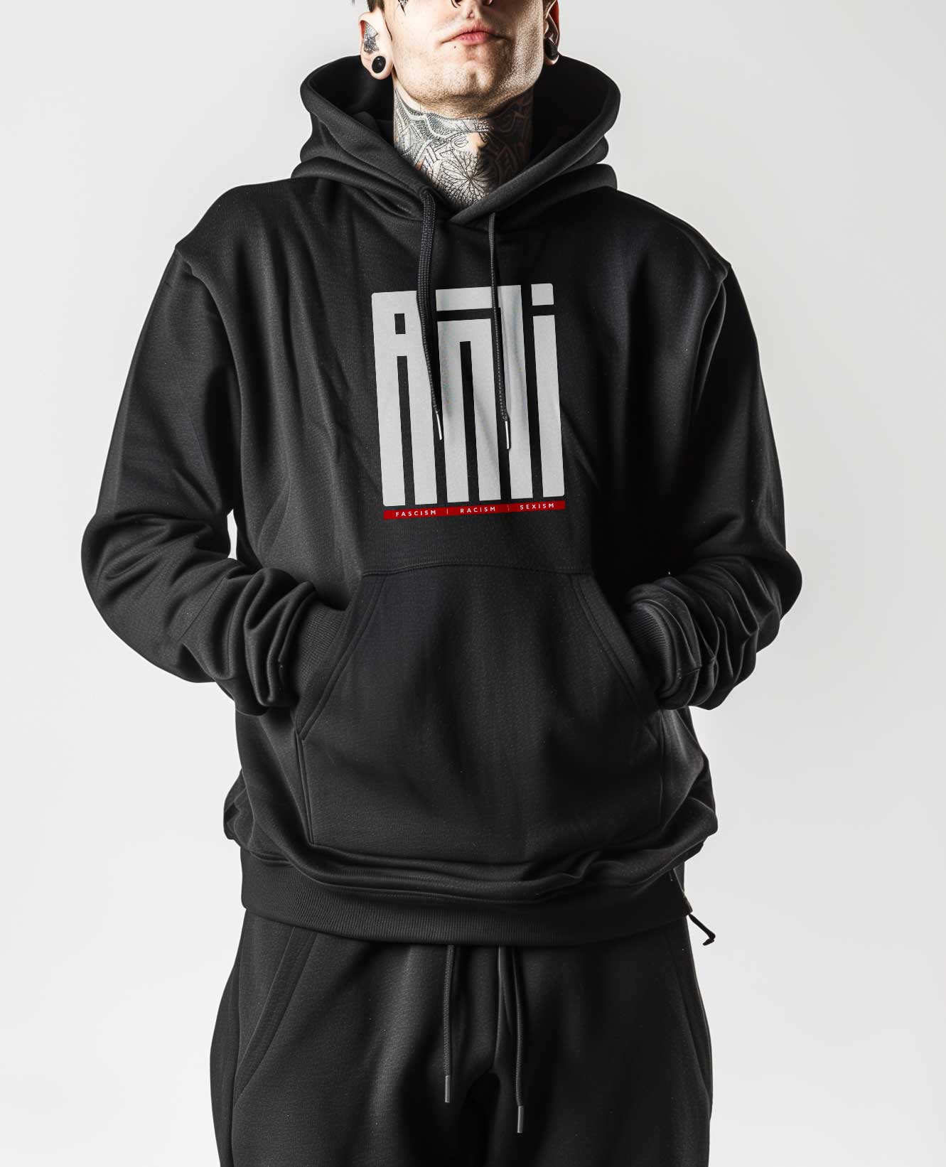Tragebild des linken Statement Motiv auf einem modernen gemütlichen Hoodie mit klarem, weißem "ANTI"-Logo in geometrischer moderner Schrift, darunter ein roter Balken auf dem in Weißer Schrift “Faschismus, Rassismus und Sexismus” steht. Linkes Statement T-Shirt Motiv für Protest und Demo. Körperbetonte passform, eher eng geschnitten.